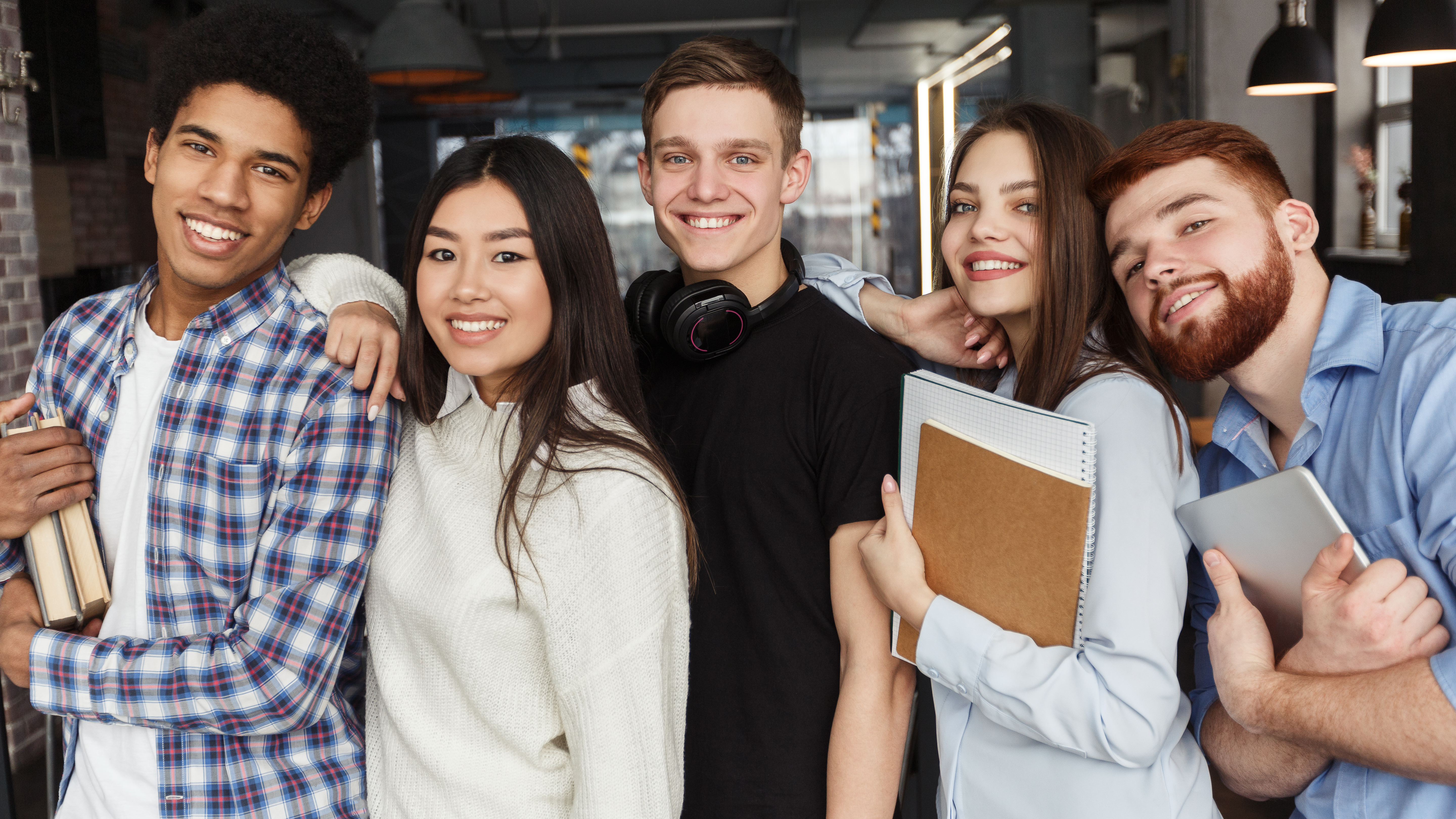 Gruppe von lachenden Absolventen und Studierenden