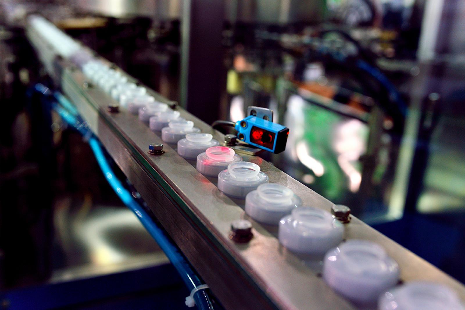 Laser scannt Objekte auf einem Förderband in einer Produktion