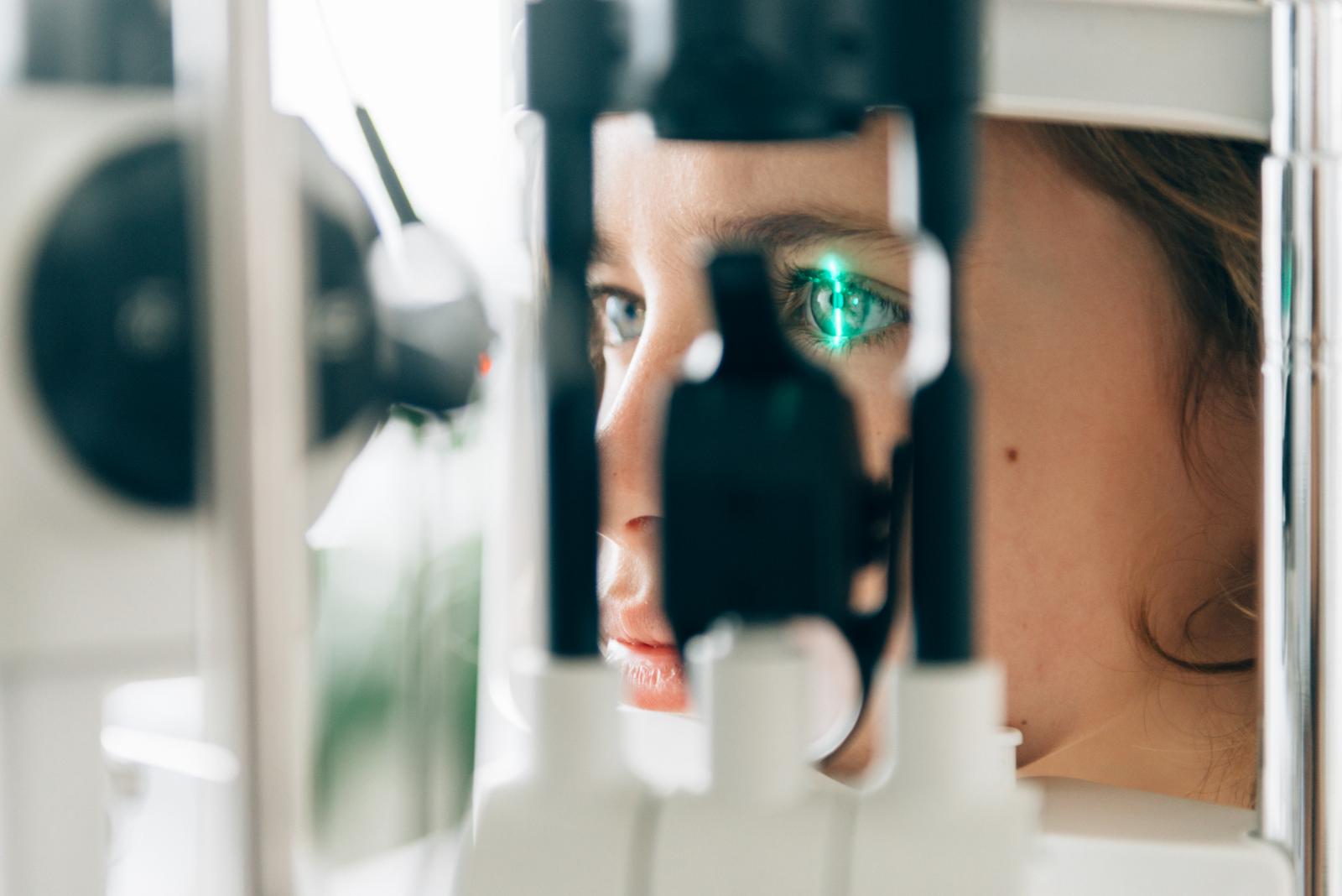 Augenarztbesuch - Laserstrahl fährt über Auge einer Patientin um Sehvermögen zu prüfen