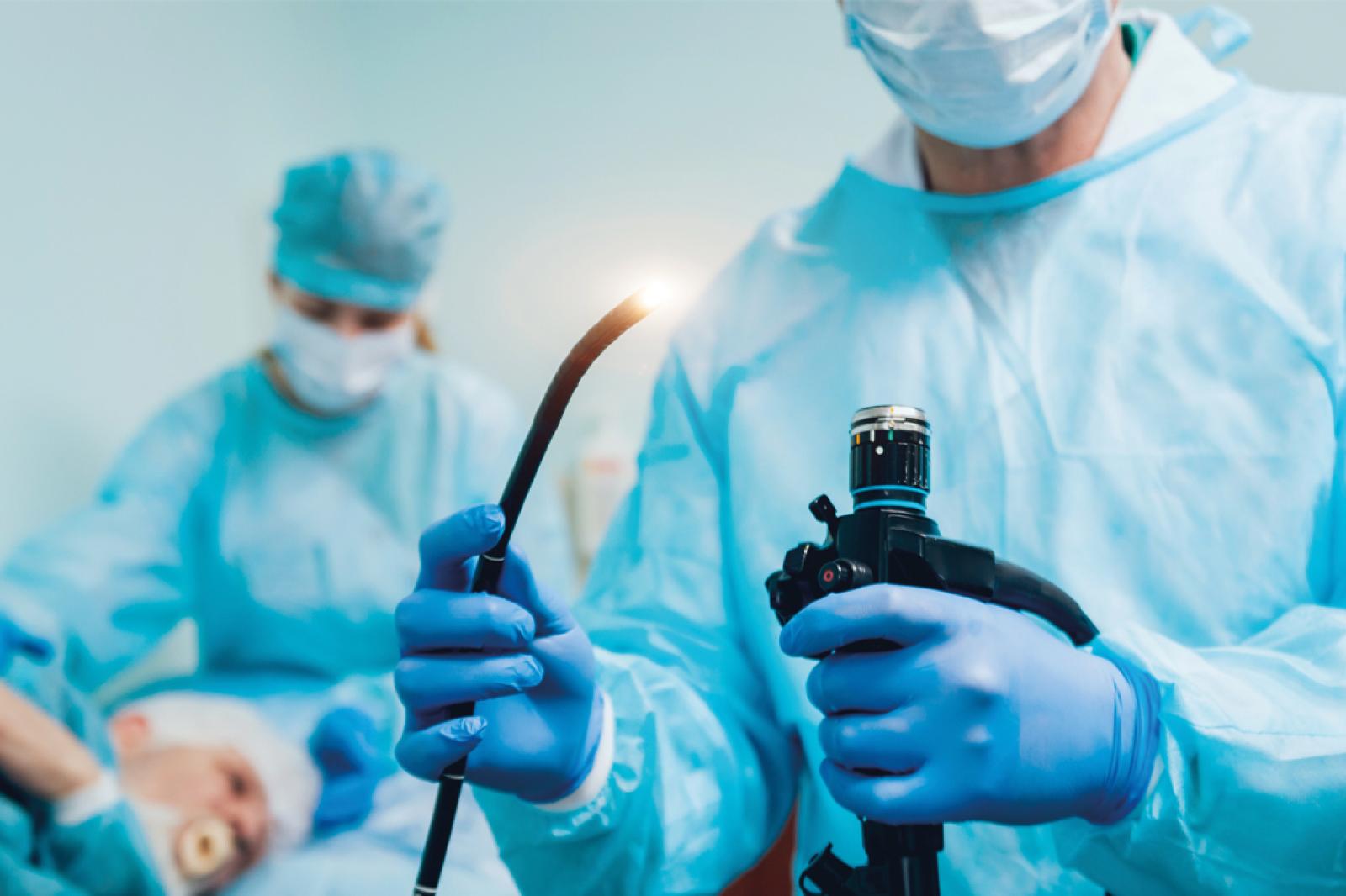Arzt hält ein Endoskop, welches für die bevorstehende Magenspiegelung (Gastroskopie) benutzt wird. 