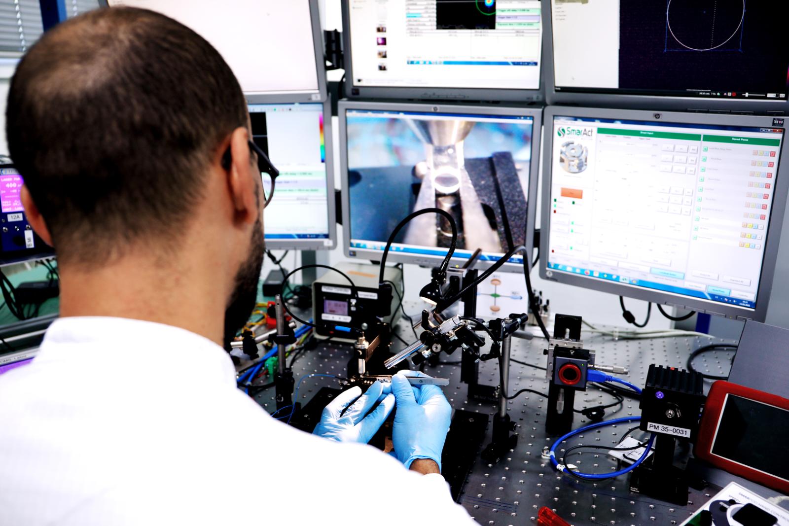FISBA Montage Mitarbeiter prüft die Linse mittels moderner Technologie - von nahe