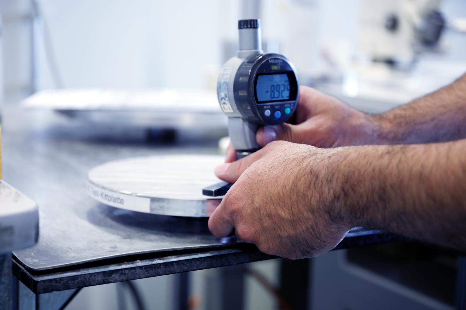 Unsere Mitarbeiter geben alles für Ihr Produkt. Ein FISBA Mitarbeiter kontrolliert den Messwert der Linsen.